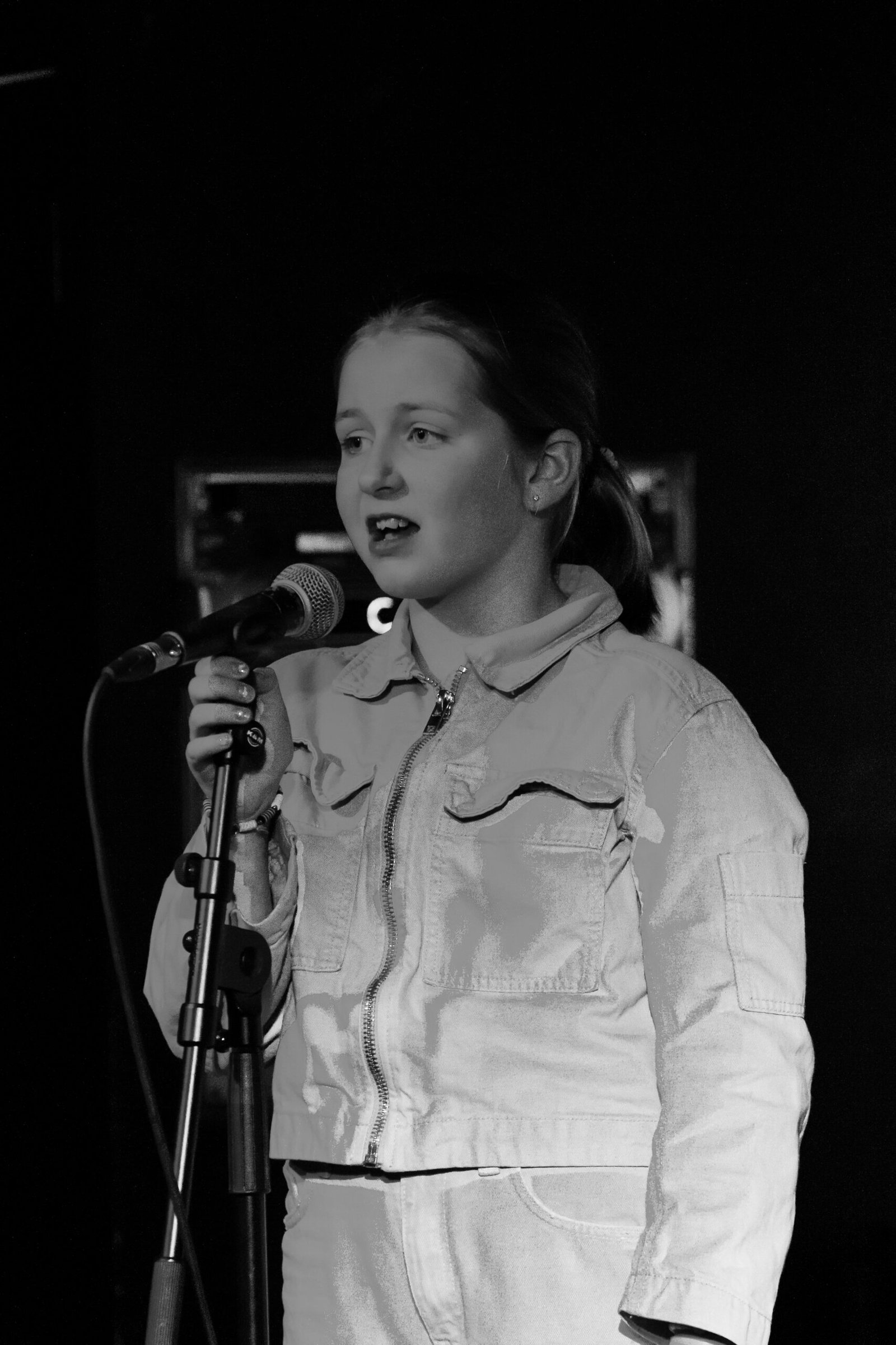 Pocket money performer Lia Ray singing at a microphone