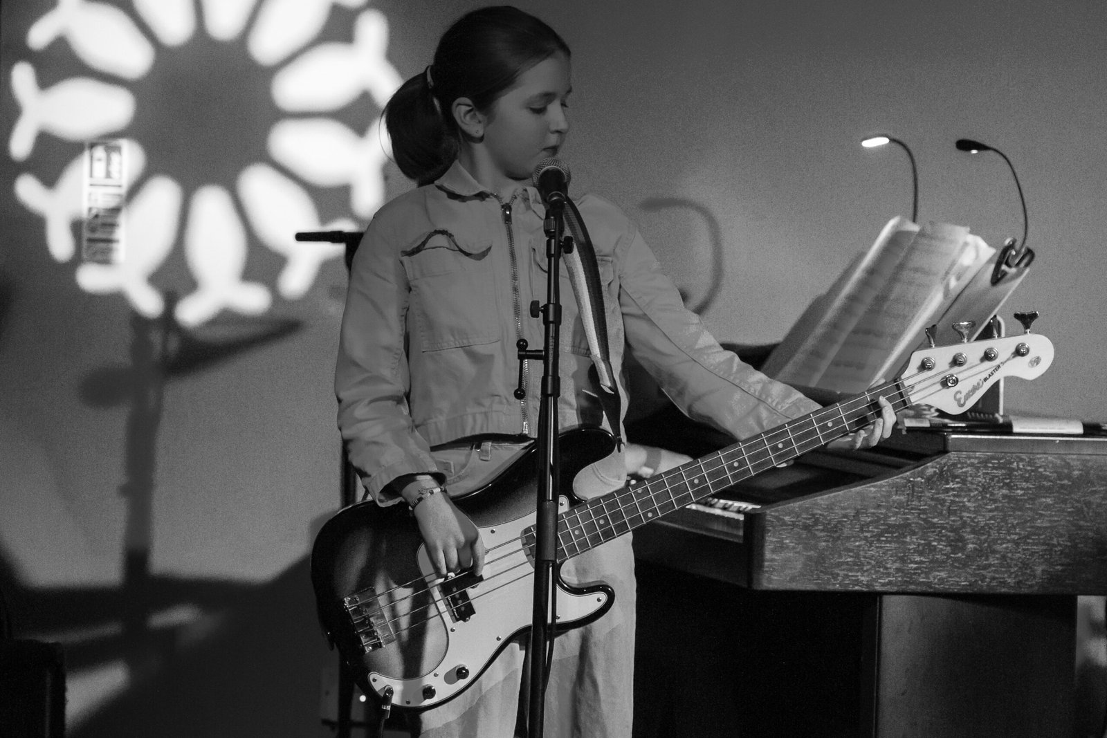 Pocket money performer Evelia Ray singing and playing bass guitar